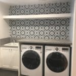 laundry room, washer and dryer, white cabienet. blue wallpaper,gray countertop.