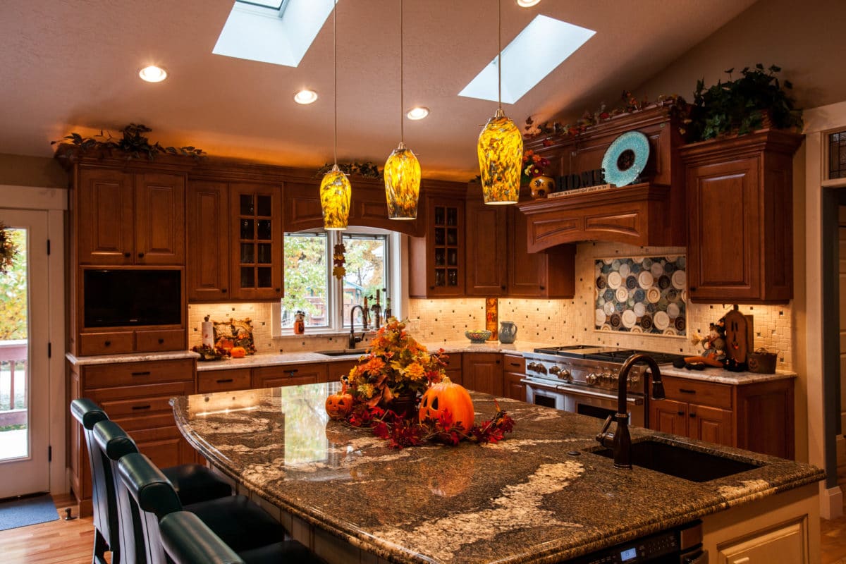 view of kitchen with a large island with granite counter. and lots of dark wood cabinets