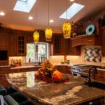 view of kitchen with a large island with granite counter. and lots of dark wood cabinets