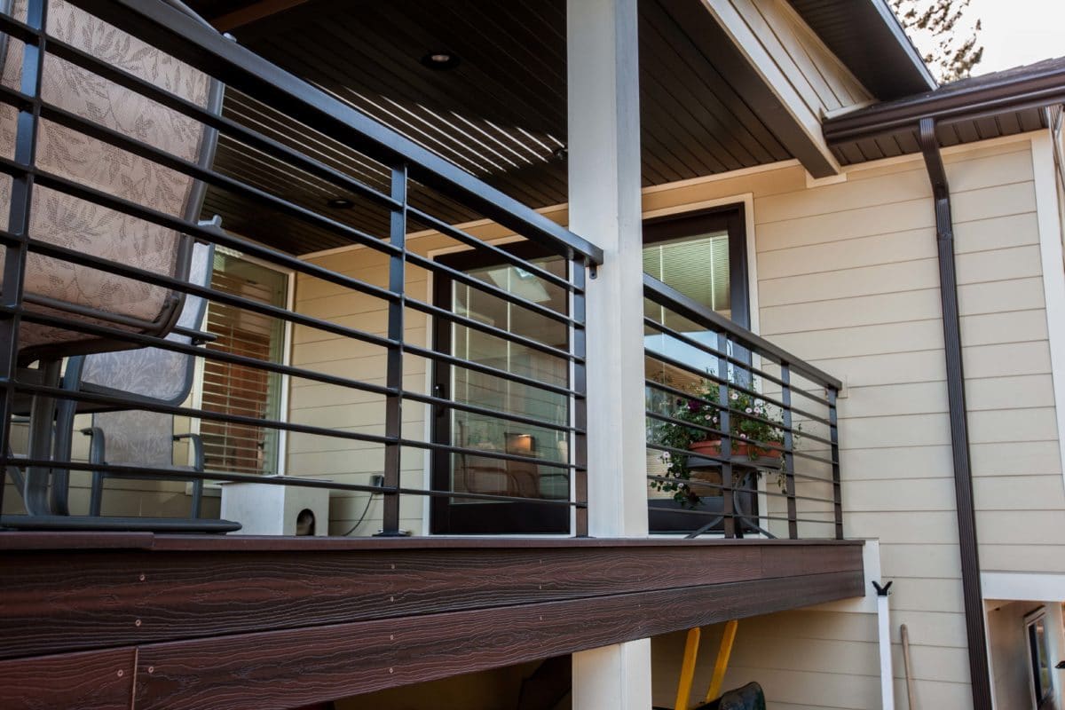 view of balcony on porch. dark metal handrails and wood flooring