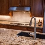 kitchen with granite counter on island with silver sink faucet