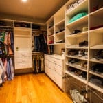 large walk-in closet with shelving, drawers and a wood floor