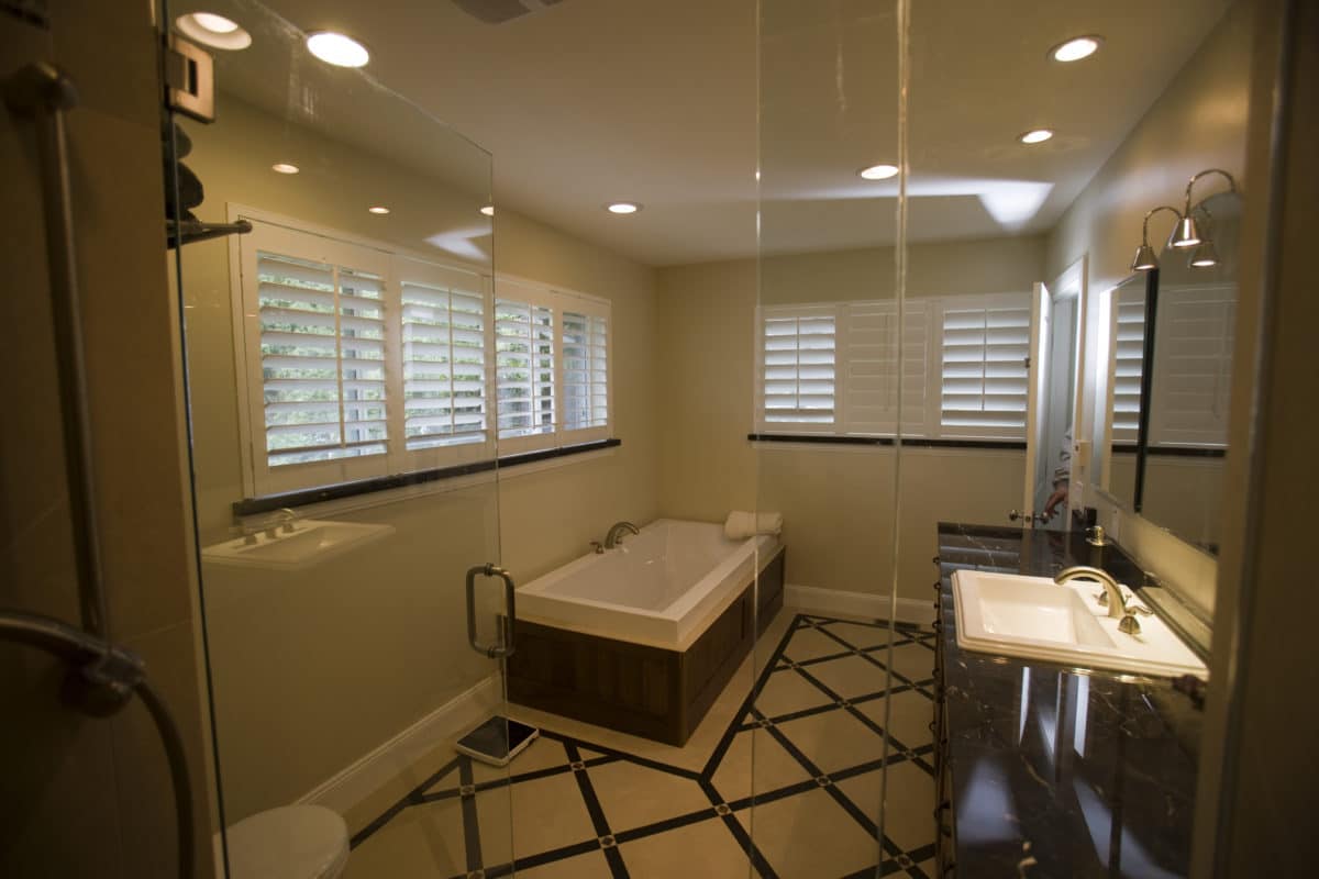 view of master bath from the shower, a bathtub on the far left wall and vanity on the right