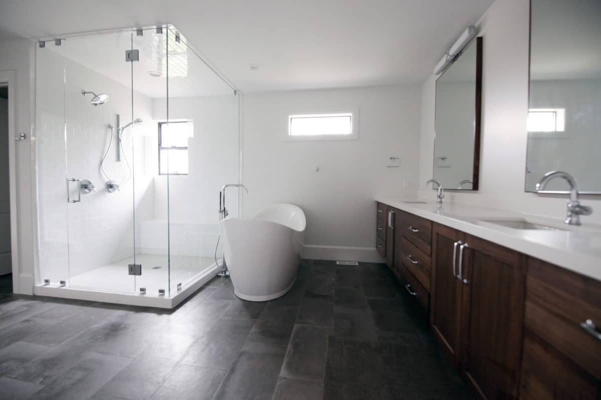 large glass shower on the left. bathtub next to the shower. vanity on the right