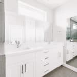 White vanity in newly remodeled bathroom large mirror