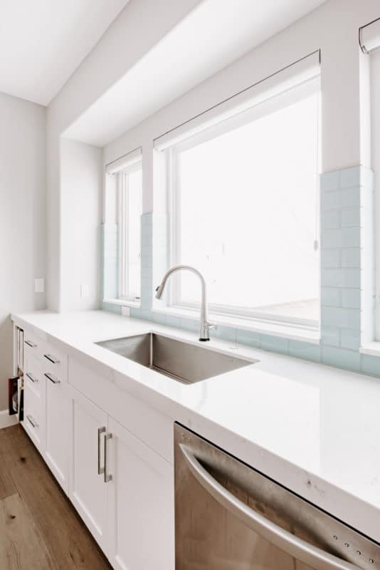 window over single basin kitchen sink, single faucet, dishwasher book shelf