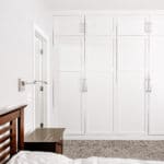 wall of white cabinets in master bedroom suite floor to ceiling cabinets