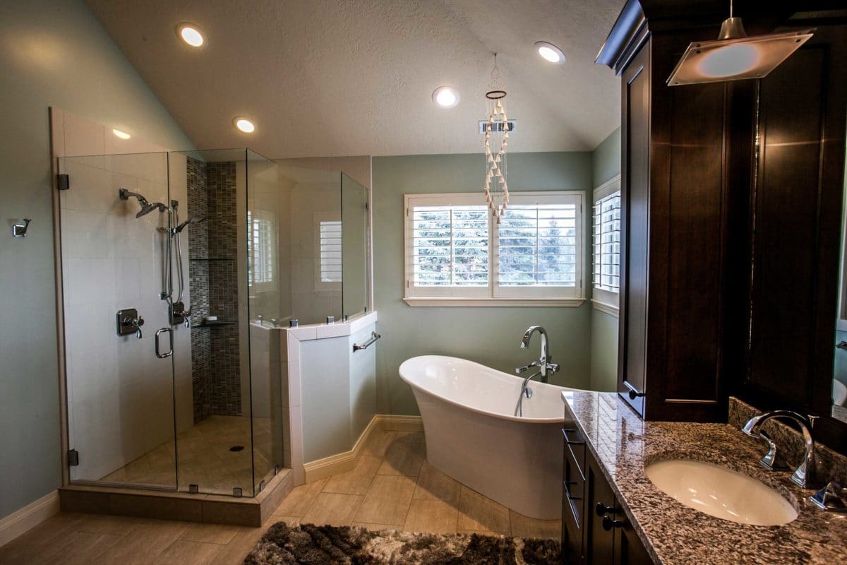 mint bathroom with large white tub , shower on the left, and countertops