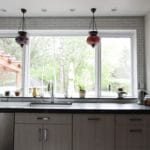 large window, with gray cabinetry and dark countertops.