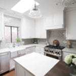 remodeled kitchen, white cabinetry with island and stove. Skylight above kitchen sink
