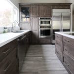 white counters with dark wooded cabinetry and silver appliences