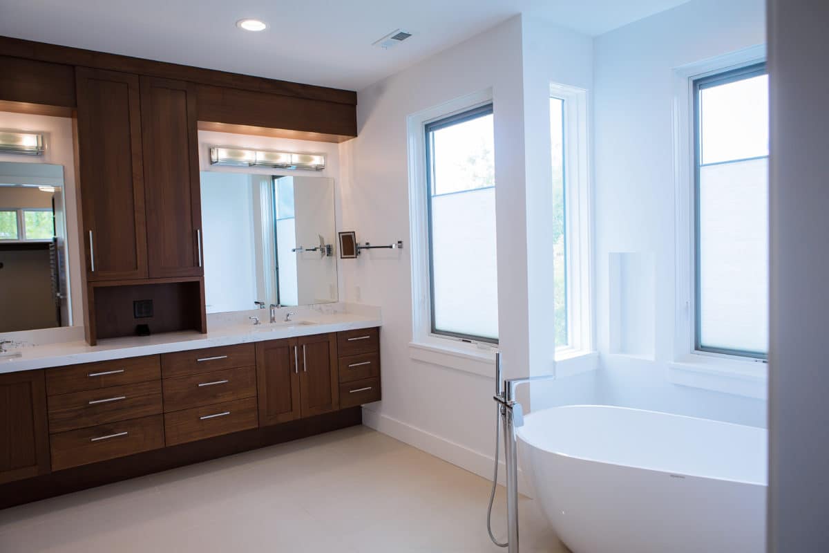 master bathroom vanity and cabinets with white freestanding tub in custom home build