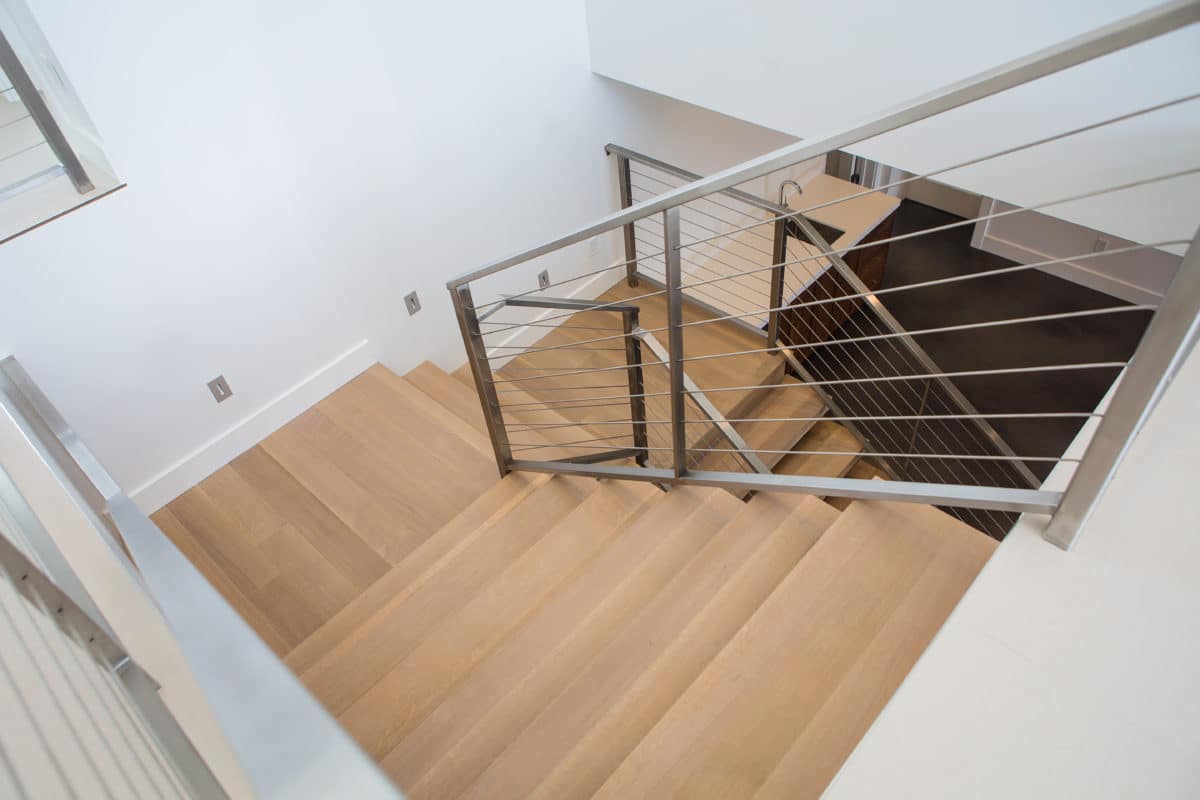 wood and metal stairs going down to basement, metal handrail