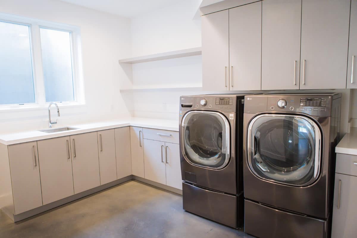 laundry room in premier new home build, open upper shelves and cabinets below window