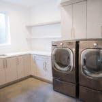 laundry room in premier new home build, open upper shelves and cabinets below window