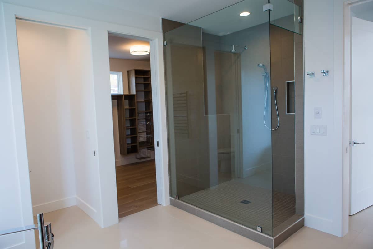 Master bathroom of luxury custom home build glass enclosed shower with closet organizers and built ins