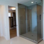 Master bathroom of luxury custom home build glass enclosed shower with closet organizers and built ins