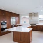 Large u shaped kitchen with island in the center. double oven. stainless hood and other appliances