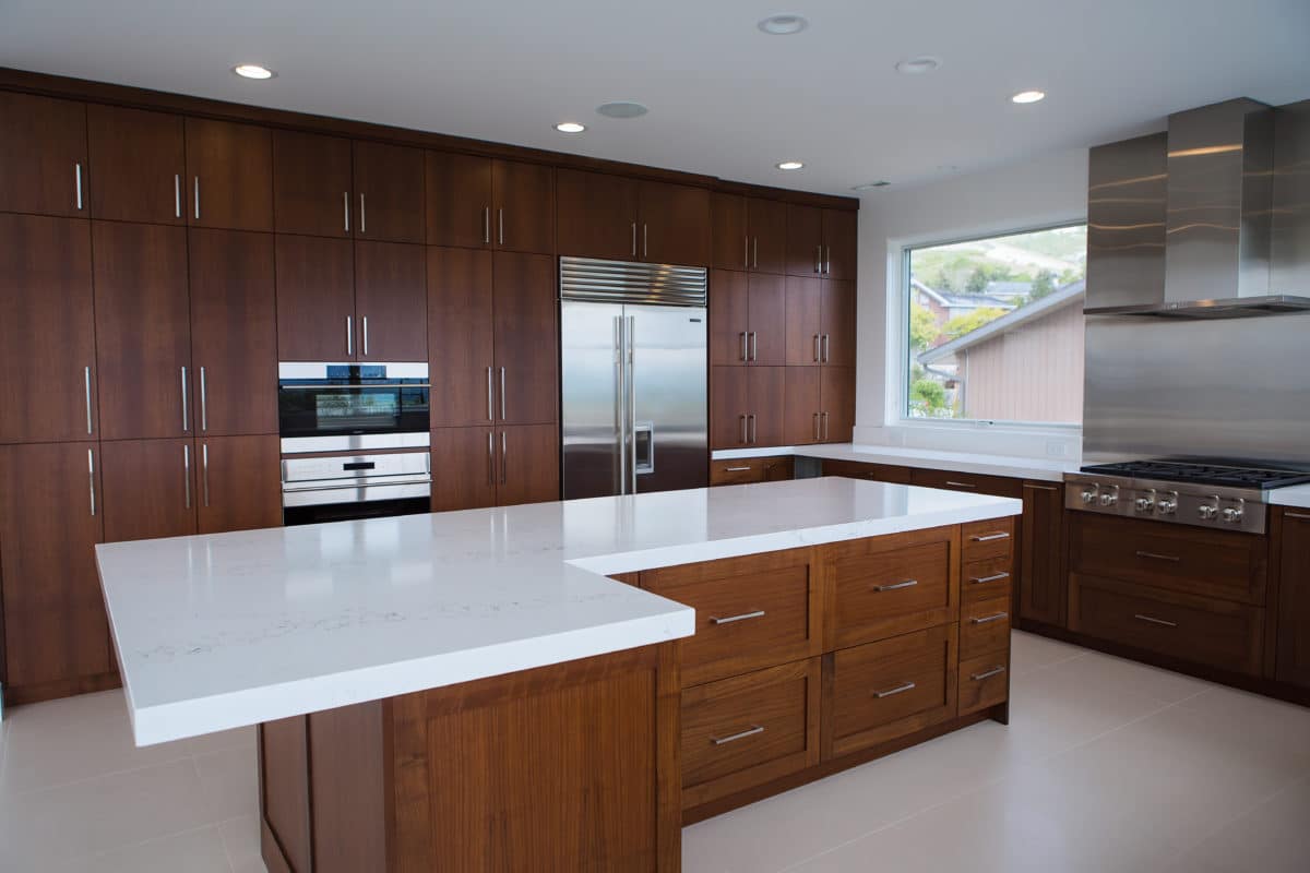 dark wood cabinets in luxury kitchen of new home build stainless appliances and white countertops