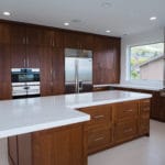 dark wood cabinets in luxury kitchen of new home build stainless appliances and white countertops