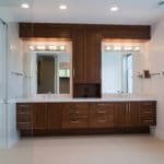 double master bathroom vanity in new custom home build two mirrors separated by cabinets in between. dark wood cabinets and white walls