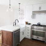 kitchen remodel with professional range stainless appliances white cabinets with black pulls, wood flooring