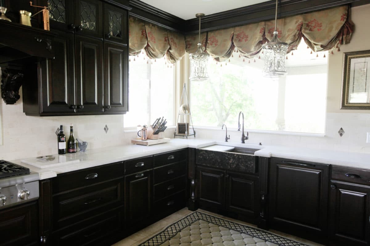 dark kitchen cabinets, windows and kitchen sink and faucet