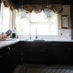 dark kitchen cabinets white countertops, farmhouse sink, dark faucet