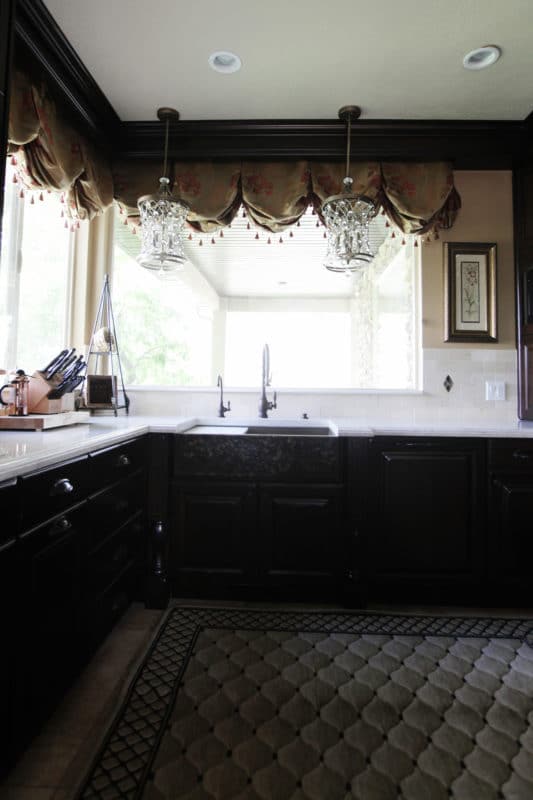 dark kitchen cabinets white countertops, farmhouse sink, dark faucet