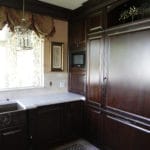 fridge matching dark wood cabinets, white countertops