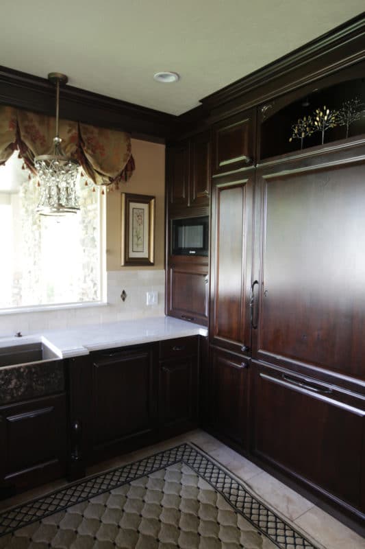 fridge matching dark wood cabinets, white countertops