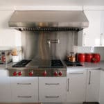 professional kitchen, white gloss cabinets, red knobs and accents