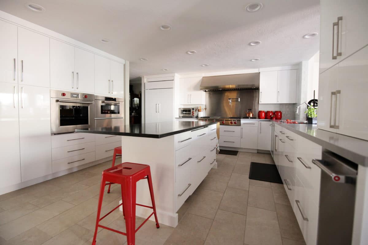 white gloss kitchen cabinets, stainless steel appliances red accents