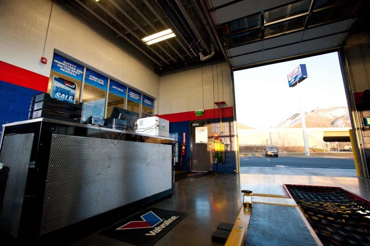 inside oil change bay of tire shop metal covered desk on left, pit on the right
