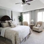 master bedroom with chairs for sitting area, fan blue grey walls, white curtains
