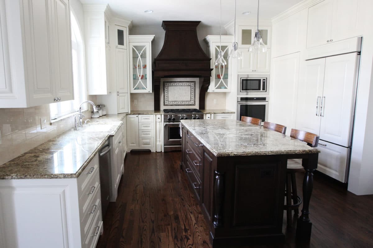white kitchen cabinets with dark hood and island, glass inlay large professional range