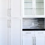 white pantry cabinet and kitchen cabinets, dark counter top