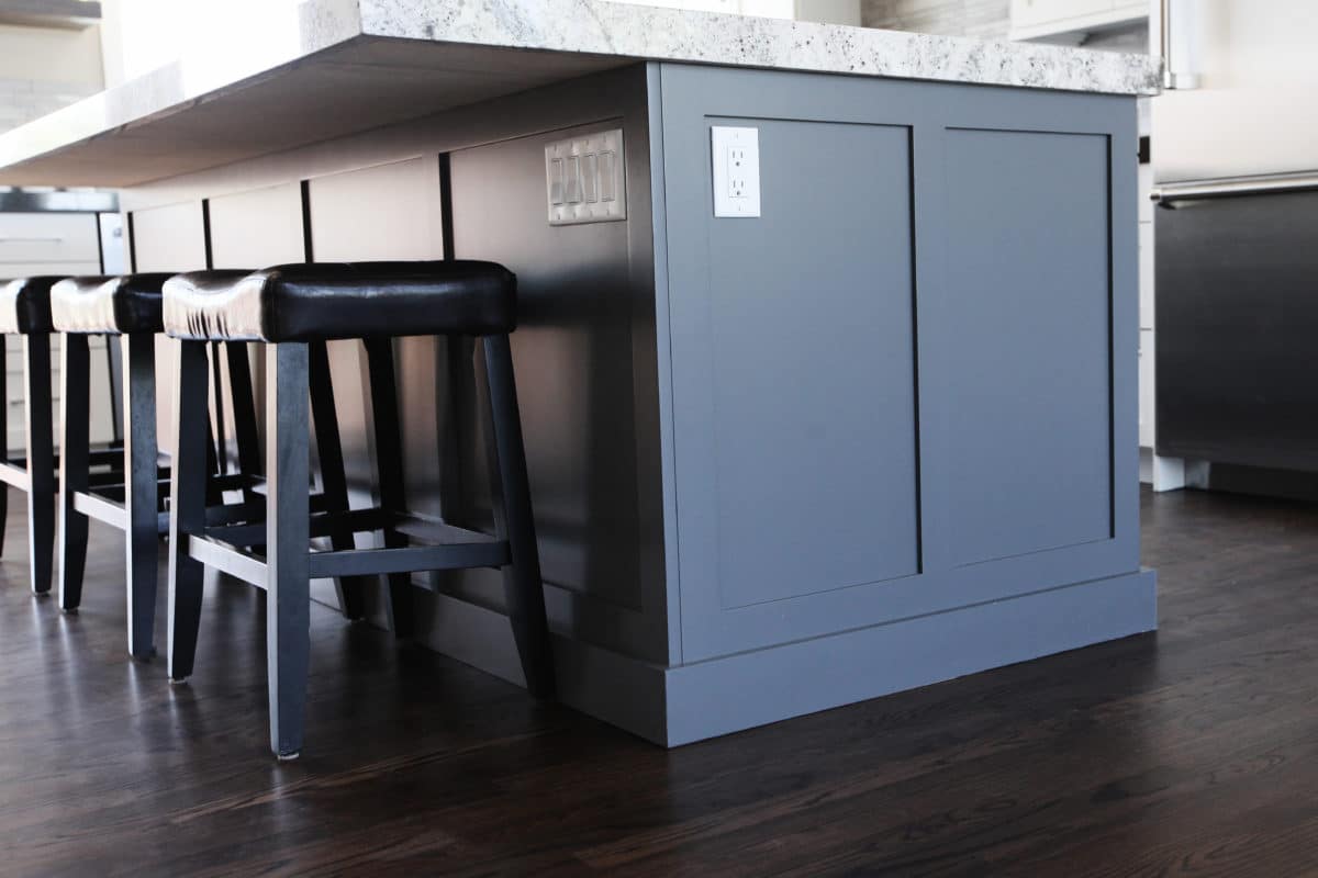 shaker style island cabinets in web gray, black bar stool, bianco romano countertop