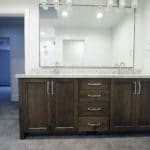 bathroom vanity from a distance, dark wood, double sinks and large mirror