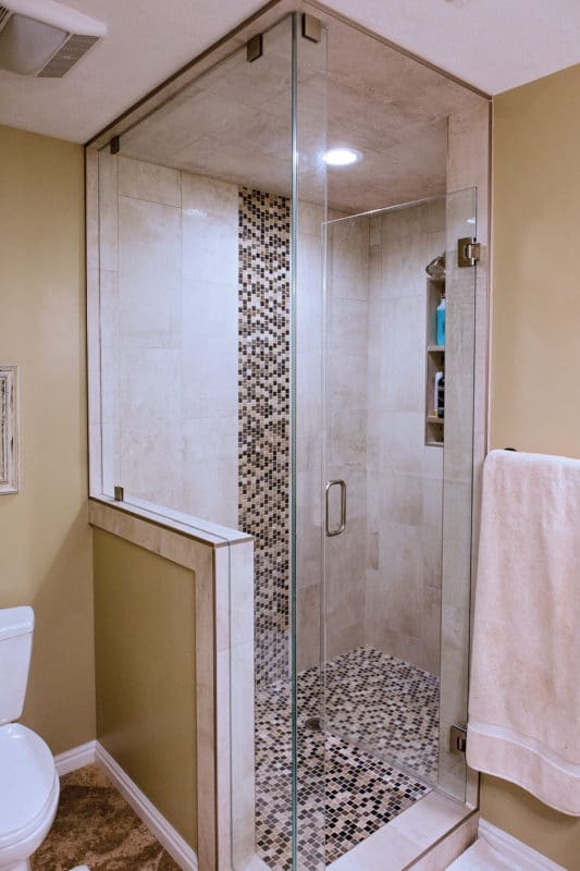 glass enclosed shower, with decorative tile