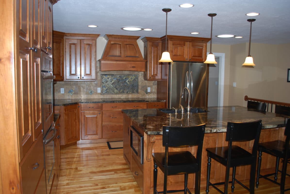 kitchen remodel wood cabinets, island with sink and microwave, tile backsplash. stainless steel appliances.