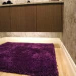 New modern bathroom remodel with natural wood floors and floating cabinets with under cabinet lights